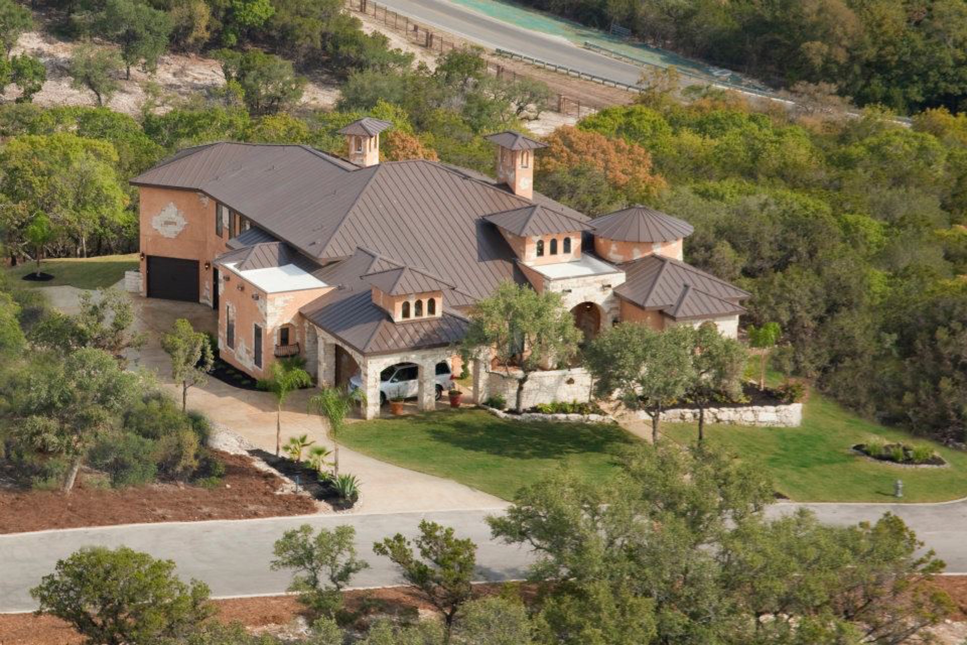 Aerial view of estate home with landscaped driveway