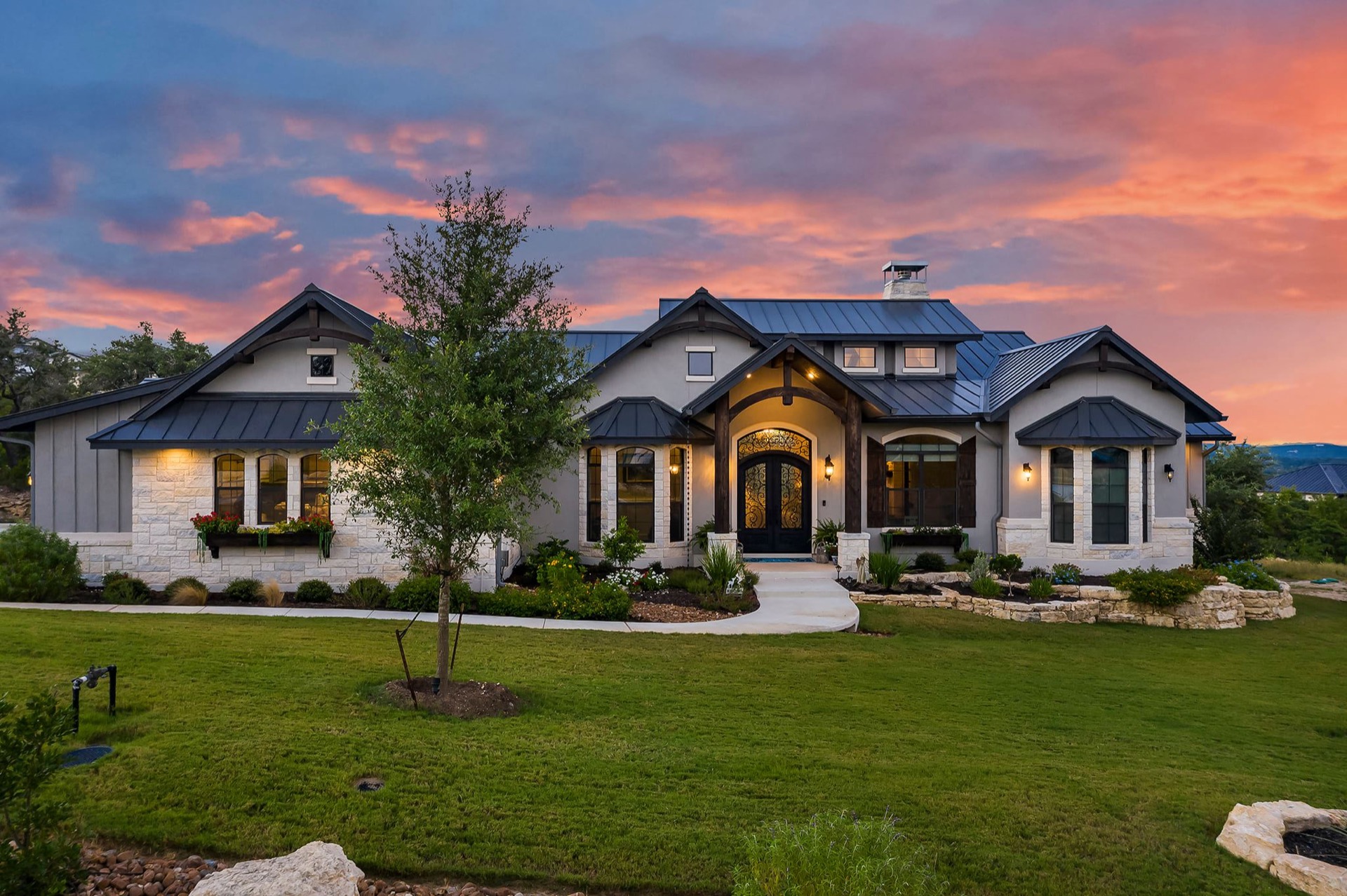 Custom stone archway home entrance lit at dusk