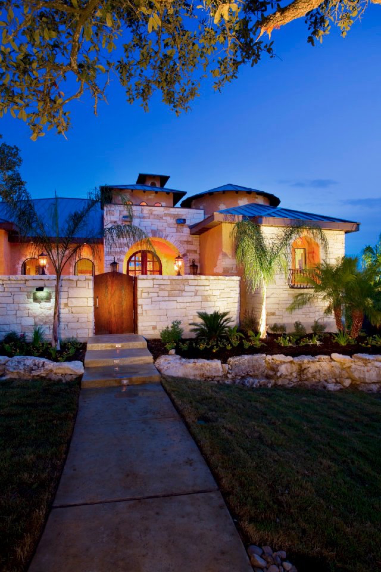 Home entry walkway with landscape uplighting at night